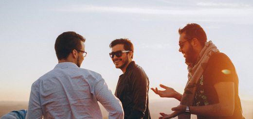 three men standing while laughing